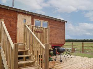 a tiny house with a staircase and a grill at Shepherds Hut in Scunthorpe