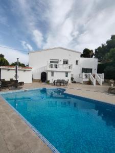a villa with a swimming pool in front of a house at Apartments in a house in Jávea