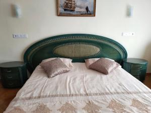 a bed with a green headboard and pillows on it at Apartments in a "VILLA VISTA JAVEA" in Jávea