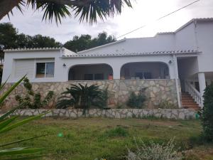 a white house with a stone fence at Apartments in a "VILLA VISTA JAVEA" in Jávea