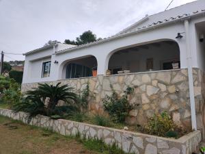 a white house with a stone retaining wall at Apartments in a "VILLA VISTA JAVEA" in Jávea