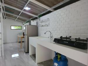 uma cozinha com um fogão e uma parede de tijolos brancos em Minimal homey 3BR near Mee Chok plaza em Chiang Mai
