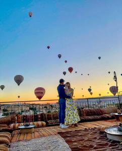 a man and woman standing on a deck with hot air balloons at Lord of Cappadocia Hotel in Goreme