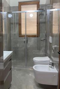uma casa de banho com um chuveiro, um WC e um lavatório. em Urban City Center em Tirana