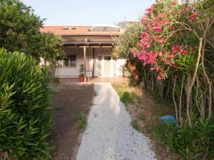 un jardín con flores rosas y una casa en Appartamento vicino al mare, en Piombino