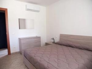 um quarto com uma cama grande num quarto branco em Bilocale vicino al mare em Piombino