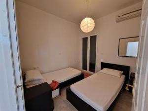 dwa łóżka w pokoju z oknem w obiekcie Olive Villa w mieście Episkopianá