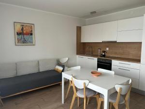 eine Küche und ein Esszimmer mit einem Tisch und einer Couch in der Unterkunft Sea Touch Apartment in Rijeka