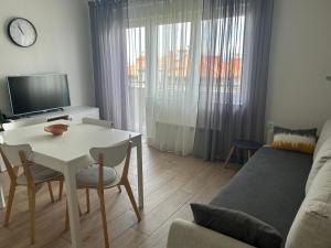 ein Wohnzimmer mit einem weißen Tisch und einer Couch in der Unterkunft Sea Touch Apartment in Rijeka