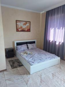 Cama blanca en habitación con ventana en Hotel ILZI en Tiflis