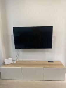 a flat screen tv sitting on top of a white cabinet at Planta baja moderna y nueva a estrenar en el centro ciudad 2 habitaciones y 2 baños in Elche