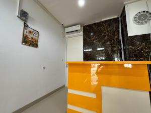 Zimmer mit orangefarbener Theke und Fenster in der Unterkunft RedDoorz at Ring Road II Area Manado in Paniki