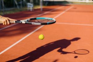 a tennis racket and a tennis ball on a tennis court at Balatontourist Füred Camping & Bungalows in Balatonfüred