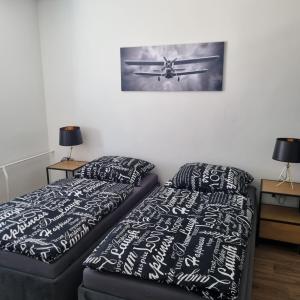 a bedroom with two beds and a picture of an airplane at Černá růže - Apartmán 3 in Plzeň