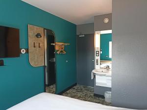 a blue bathroom with a sink and a mirror at B&B HOTEL Calais Terminal Cité Europe 2 étoiles in Coquelles