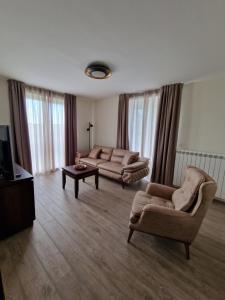 ein Wohnzimmer mit 2 Sofas und einem TV in der Unterkunft Vikendica Aleksandrović Meterize in Topola