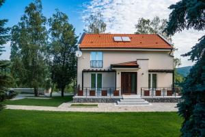 ein weißes Haus mit orangefarbenem Dach in der Unterkunft Vikendica Aleksandrović Meterize in Topola