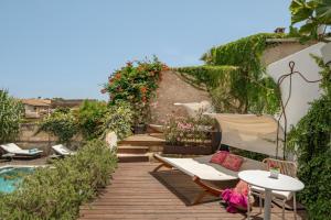 una terraza de madera con sillas y una mesa junto a la piscina en Can Joan Capo - Adults Only, en Sineu