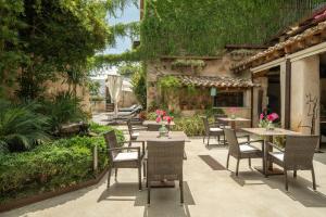 un patio al aire libre con mesas, sillas y plantas en Can Joan Capo - Adults Only en Sineu