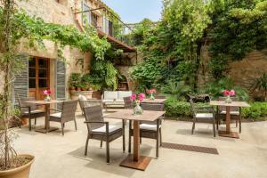 un patio al aire libre con mesas, sillas y plantas en Can Joan Capo - Adults Only, en Sineu