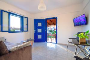 a living room with a couch and a blue door at Blue Breeze in Milatos