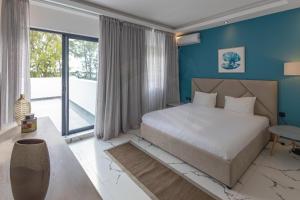 a bedroom with a large bed and blue walls at O'Beach Boutique Studios in Flic-en-Flac