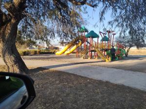 um parque com um parque infantil com um escorrega amarelo em Loft Aeropuerto Salta em General Alvarado