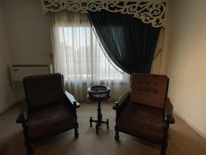 two chairs and a table in front of a window at Cheerful Spacious Apartment in Rehab City , Fully Equipped, Guest First Choice & Best Offer in The City مدينة الرحاب in Cairo