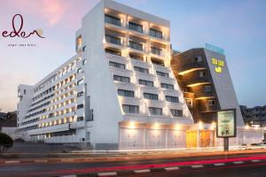 a large hotel with a building next to a street at דירת סטודיו עם מרפסת במתחם סי סייד - By Edomlux in Eilat