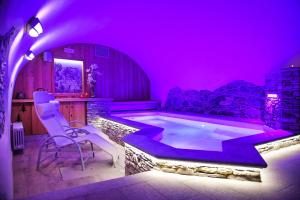 a purple room with a pool with chairs and a table at Le Petit Fenestrelle Albergo Diffuso in Fenestrelle