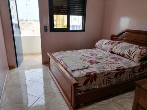 a bedroom with a bed in a room with a window at apparts Large in Oualidia