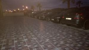 a row of cars parked in a parking lot at night at apparts Large in Oualidia +3 photos