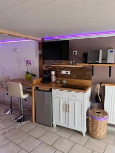 - une cuisine avec un bureau, un four micro-ondes et une table dans l'établissement Au Fil De l' Eau, à Aurec-sur-Loire