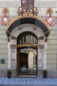 uma entrada para um edifício com um arco sobre uma loja em K+K Hotel Central em Praga