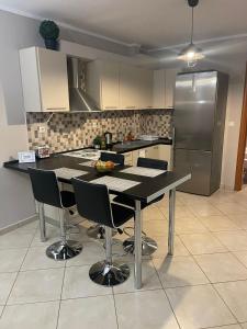 y cocina con mesa, sillas y nevera. en MF Apartment, en Nea Kalikratia