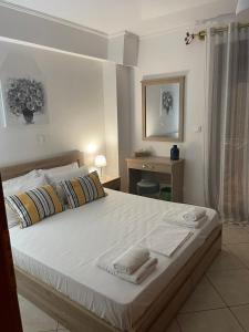 1 dormitorio con 1 cama grande y toallas. en MF Apartment, en Nea Kalikratia