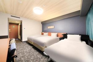 a hotel room with two beds and a window at Richmond Hotel Yokohama-Bashamichi in Yokohama