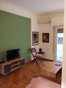 a living room with a television and a chair at Vasia's cosy apartment in Athens, "Pedion tou Areos", close to center in Athens