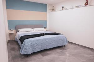 sypialnia z łóżkiem z niebiesko-białą ścianą w obiekcie Centro Storico Luxury Suites - affittacamere guesthouse in historical center Toledo station w mieście Neapol