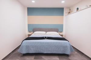 a bedroom with a bed with a blue and white wall at [Centro Storico] Luxury Suites in Naples