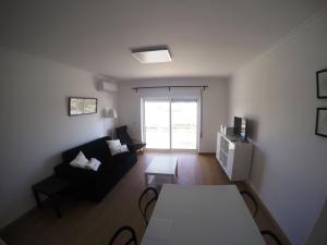Monte Gordo Prestige Apartments في مونت غوردو: غرفة معيشة مع أريكة وطاولة