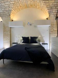 ディジョンにあるLOFT Spa Gare Cité Gastronomique Dijonの石壁のベッドルーム1室(大型ベッド1台付)