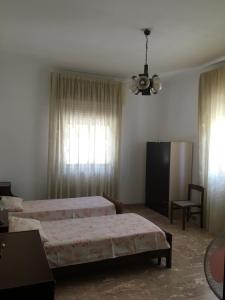 una camera d'albergo con due letti e una sedia di Affittacamere al piano terra a Scicli