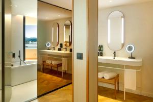 a bathroom with two sinks and two mirrors at TRS Ibiza Hotel - Adults Only in San Antonio