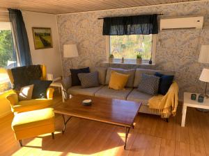 ein Wohnzimmer mit einem Sofa und einem Couchtisch in der Unterkunft Cozy and Private 3-Bed House with bath Roslagen in Herräng