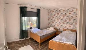 two beds in a small room with a window at Immaculat 4 Bed Apartment in Karlskrona in Karlskrona