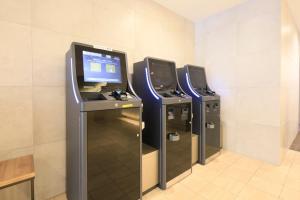 a row of three video game machines in a room at Richmond Hotel Yokohama-Bashamichi in Yokohama