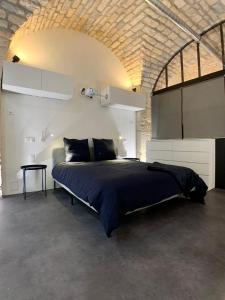 ディジョンにあるLOFT Spa Gare Cité Gastronomique Dijonのレンガの壁のベッドルーム1室(大型ベッド1台付)