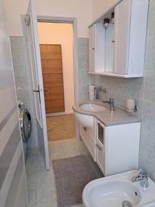 a white bathroom with a sink and a toilet at Casa Gelsomino in Rimini