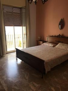 a bedroom with a large bed and a large window at Affittacamere al piano terra in Scicli